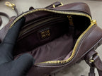Dark brown top-handle bag interior open, showing logo patch and zip lining