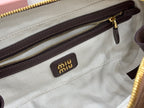 Chevron-lined interior pocket with brown trim and Miu Miu logo patch