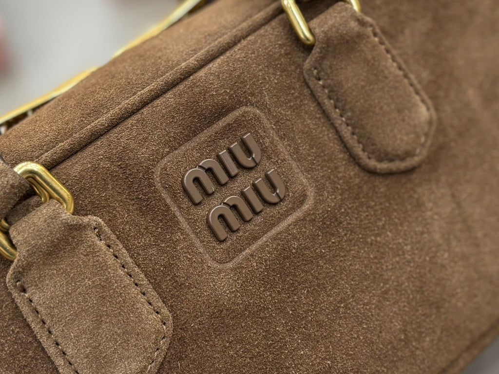 Miu Miu logo patch on suede mini bag with gold-tone hardware and strap tabs
