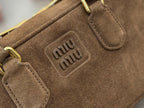 Miu Miu logo patch on suede mini bag with gold-tone hardware and strap tabs
