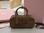 Suede top-handle mini bag with gold-tone hardware, front logo, and two strap tabs
