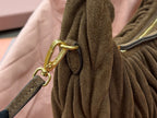 MiuMiu ruched hobo bag handle close-up, olive-brown strap with gold clasp