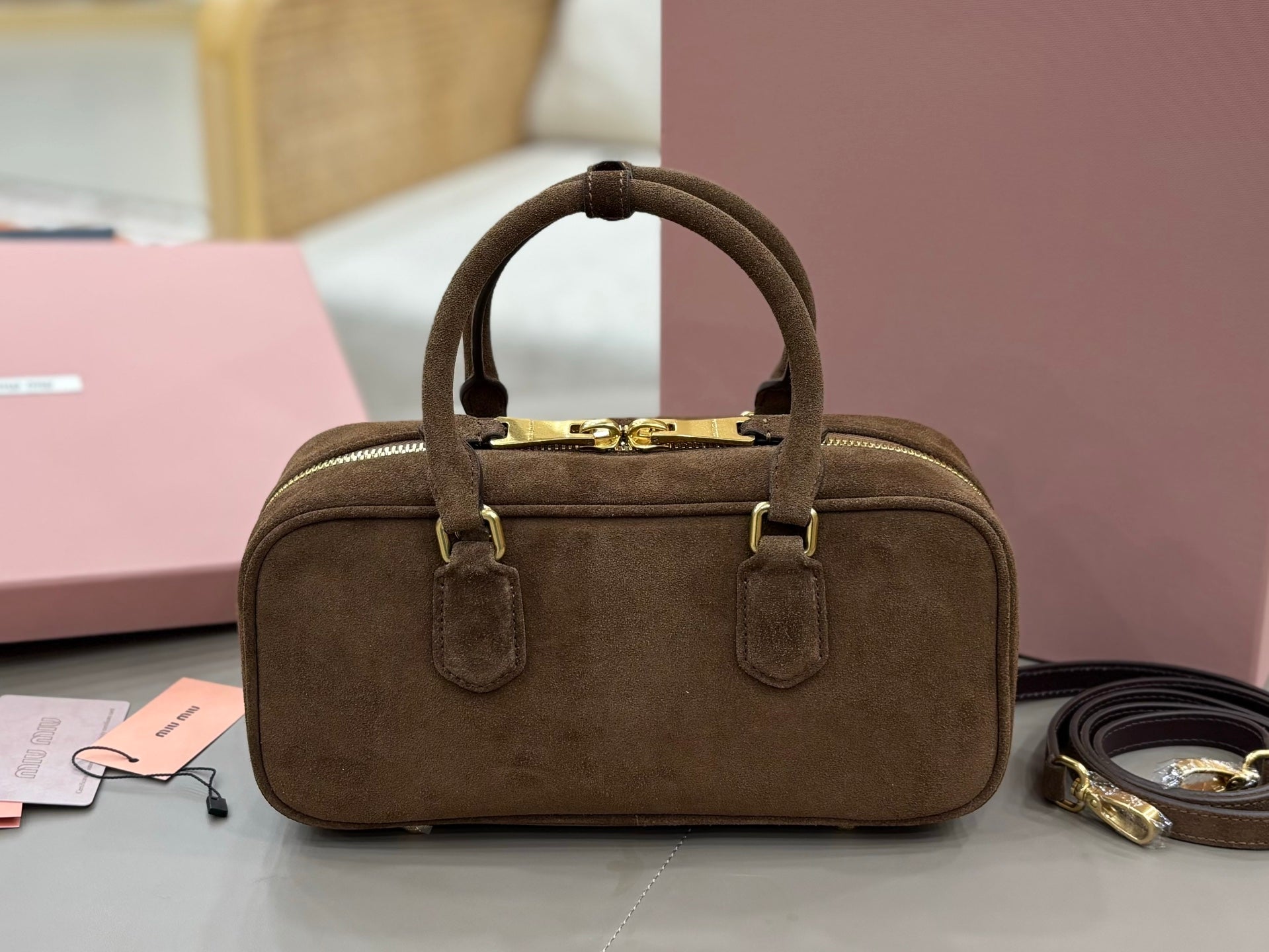 Suede rectangular top-handle mini bag with gold-tone clasp hardware and front logo