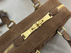 Suede mini handbag close-up of gold zipper hardware and front latch detail
