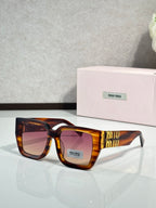 Square tortoise sunglasses with amber-tinted lenses and gold “miu miu” temple logo