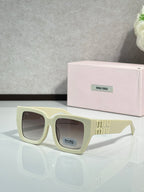 Square cream sunglasses with dark lenses and gold “miu miu” logo on the temple