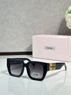 Square sunglasses with dark navy frames, black lenses, and gold logo at the temple