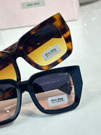 Tortoise and navy square sunglasses with tinted lenses, showing “miu miu” branding on arms