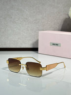 Gold-tone sunglasses with brown gradient lenses and logo on the temple arms