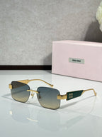 Gold-tone sunglasses with dark gradient lenses and Miu Miu logo on the temples