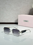 Gold-tone sunglasses with dark gradient lenses and logo on the temple arms