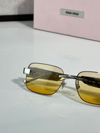 Gold-tone sunglasses with dark gradient lens and logo temple detail