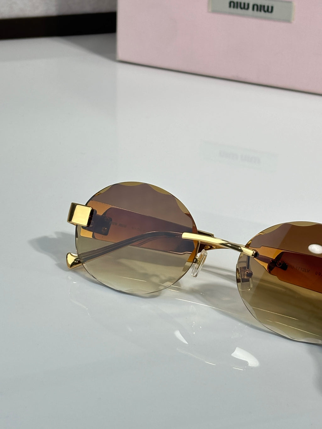 MiuMiu sunglasses with gold metal frame and dark brown lenses