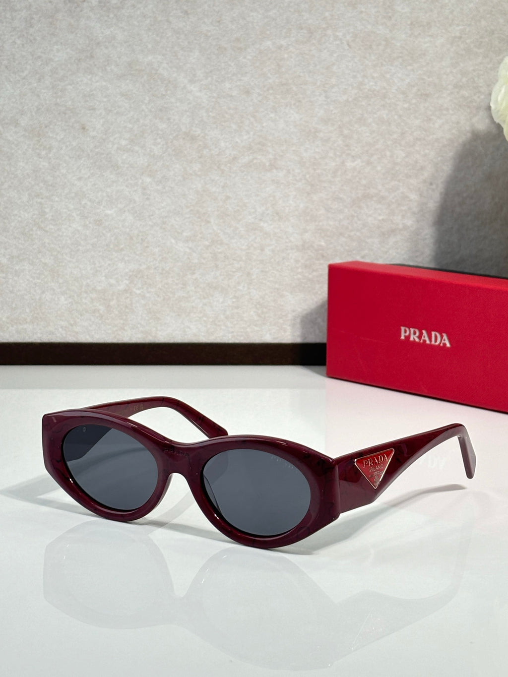 Prada burgundy cat-eye sunglasses with dark lenses and sculpted temples