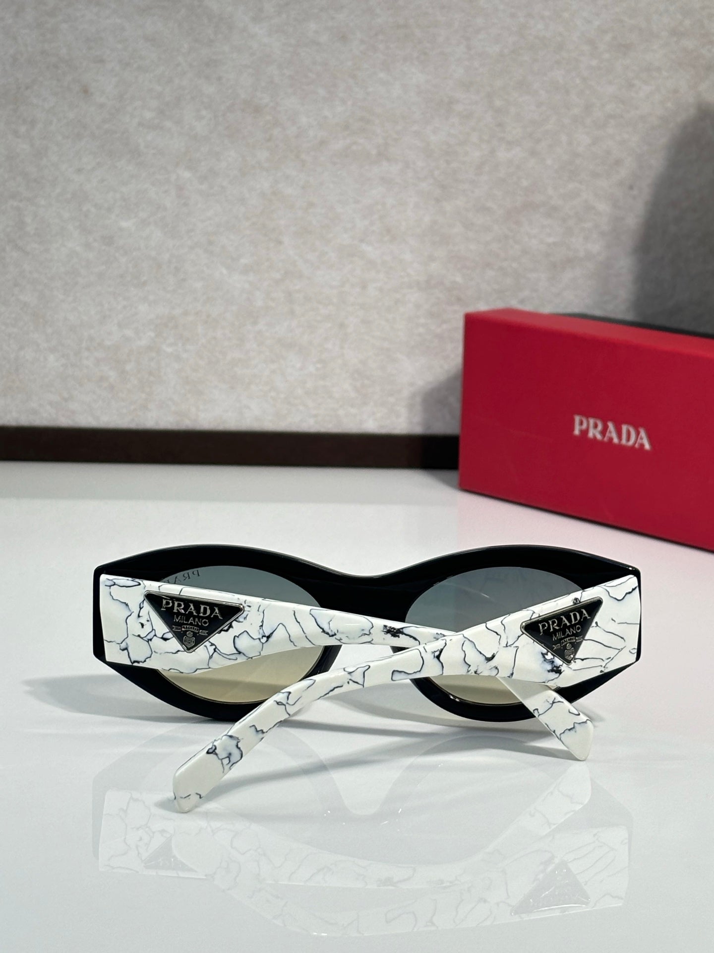 Prada white patterned sunglasses with dark lenses and straight temple detail