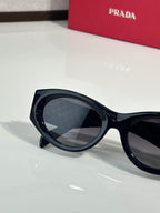 Prada black sunglasses with dark lenses and smooth rounded frame