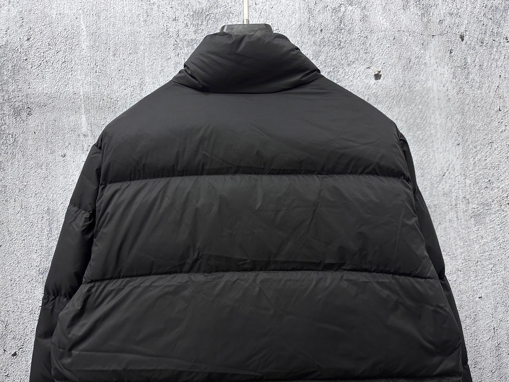 Long puffer jacket back view in dark color with raised collar