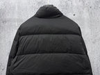 Long puffer jacket back view in dark color with raised collar