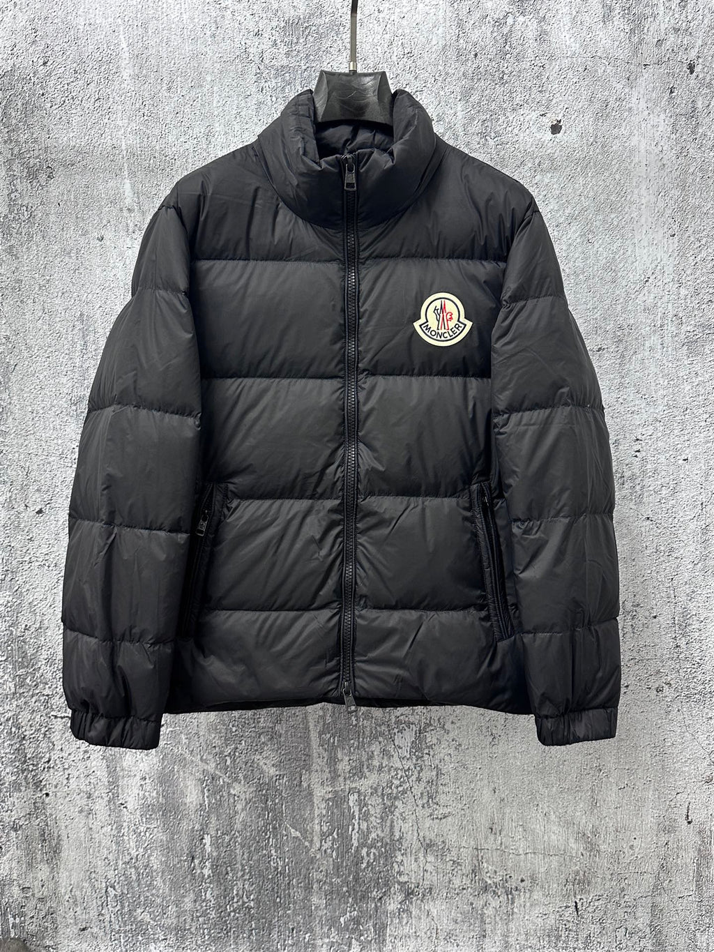 Long puffer jacket, dark color, front zip and small chest logo patch