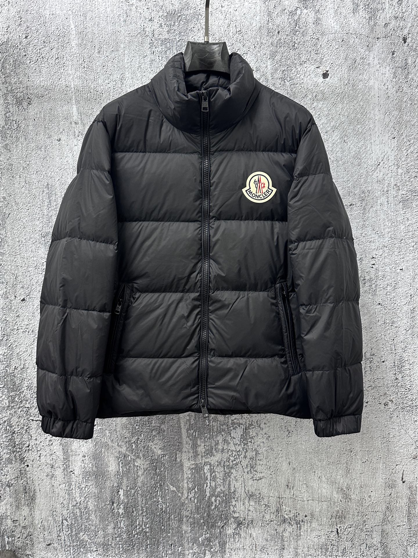 Long puffer jacket, dark color, front zip and small chest logo patch