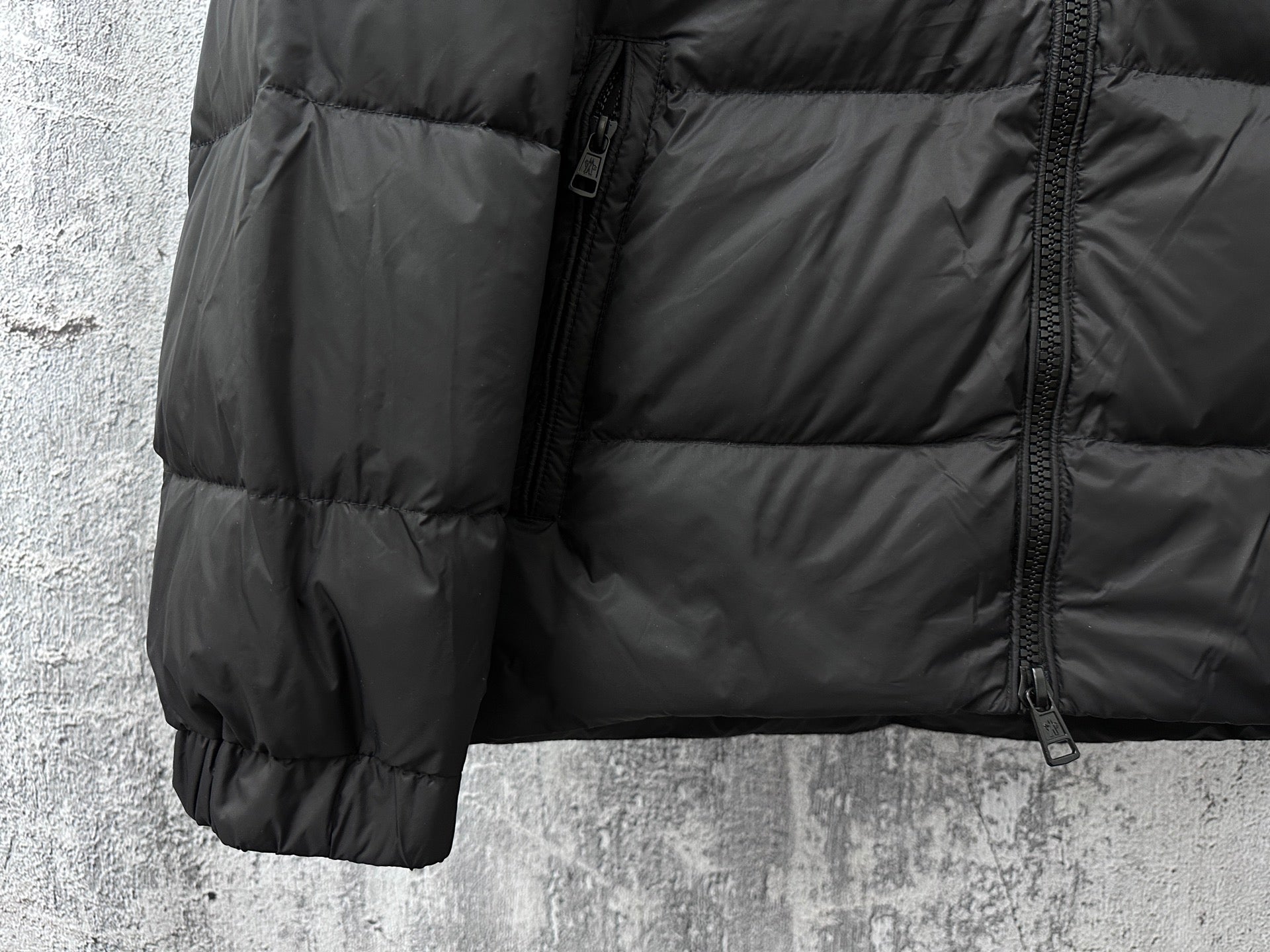 Long puffer jacket side with quilted panels, front zipper, and pocket
