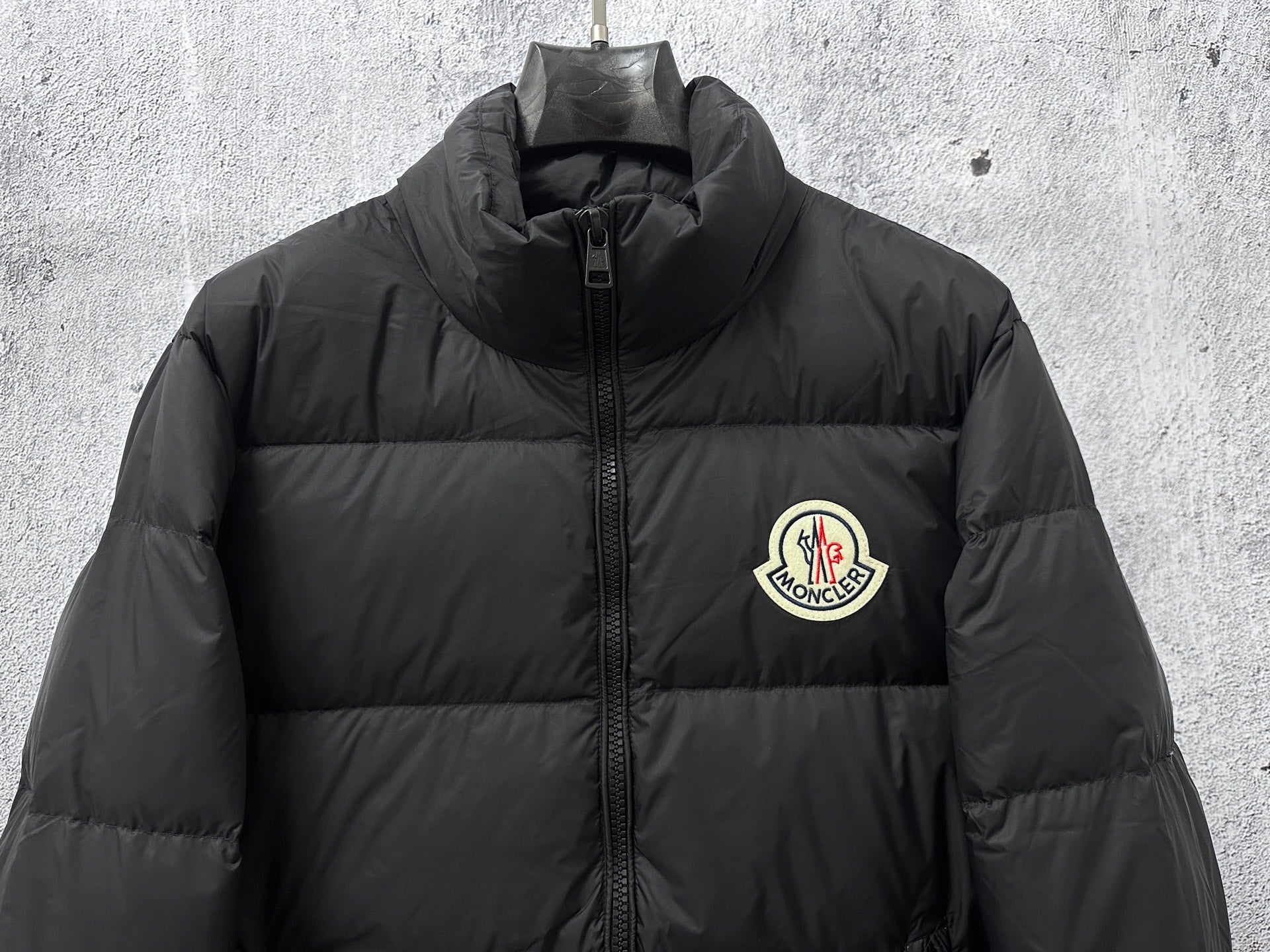 Long puffer jacket upper front with front zipper and chest logo patch