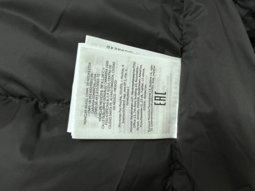 Long puffer jacket interior label tag on dark fabric