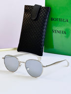 Round sunglasses with silver frame and light blue lenses, with black leather case