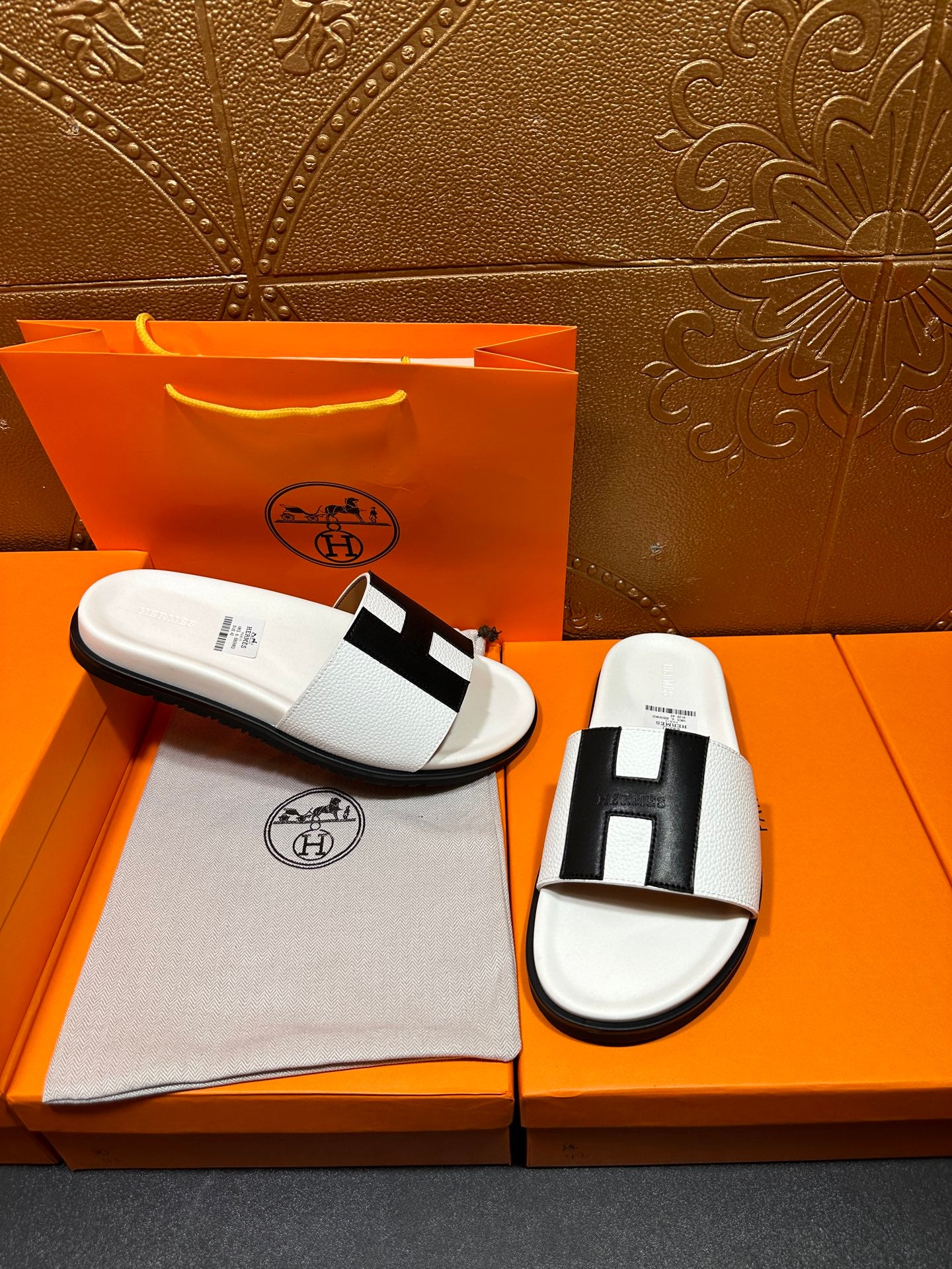 Hermes slide sandals pair: white slide with black H-style cross strap