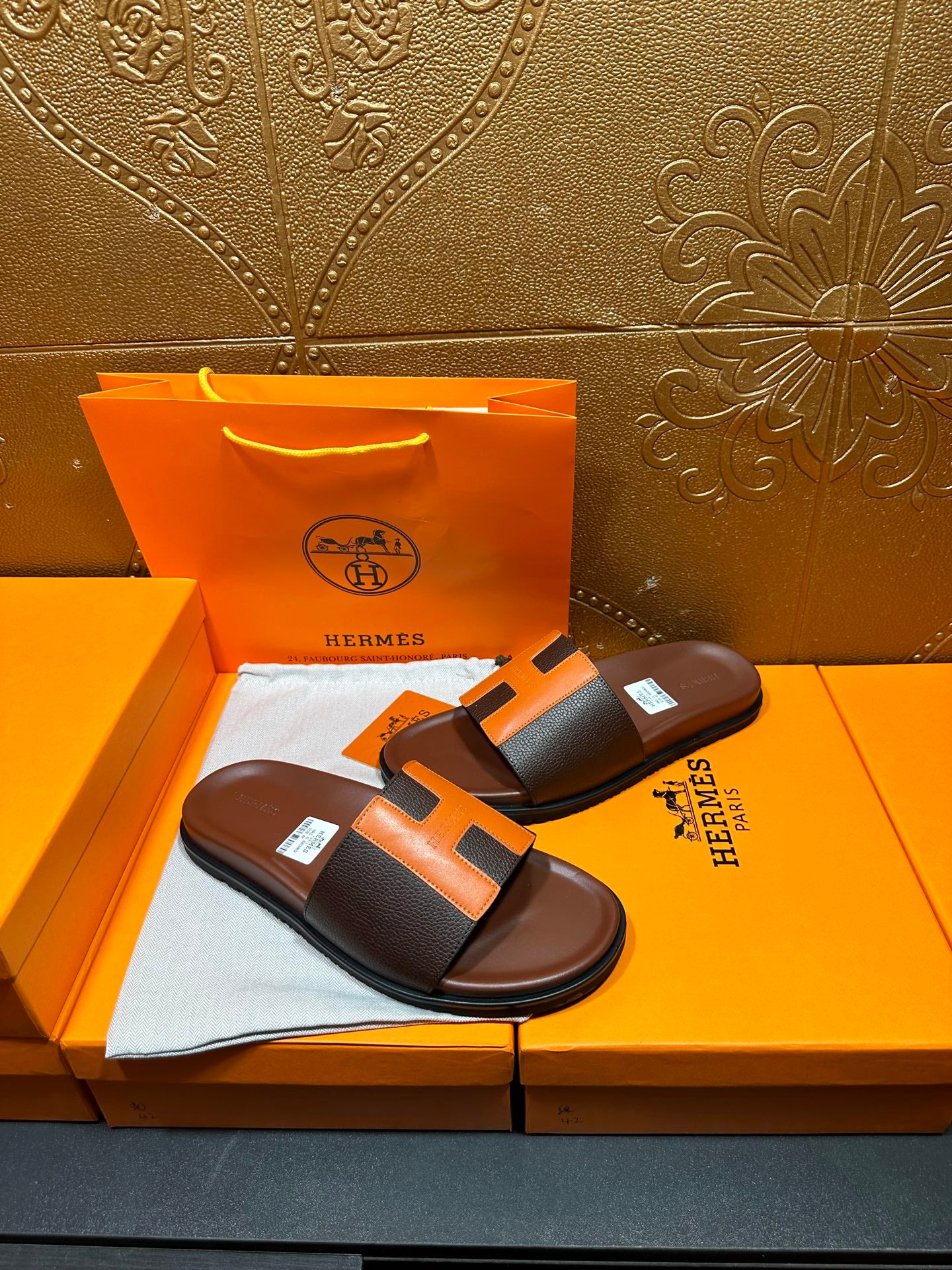 Leather sandals with orange H strap detail, dark footbed, pair on Hermes box