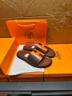 Leather sandals with orange H strap detail and dark footbed, single pair on box