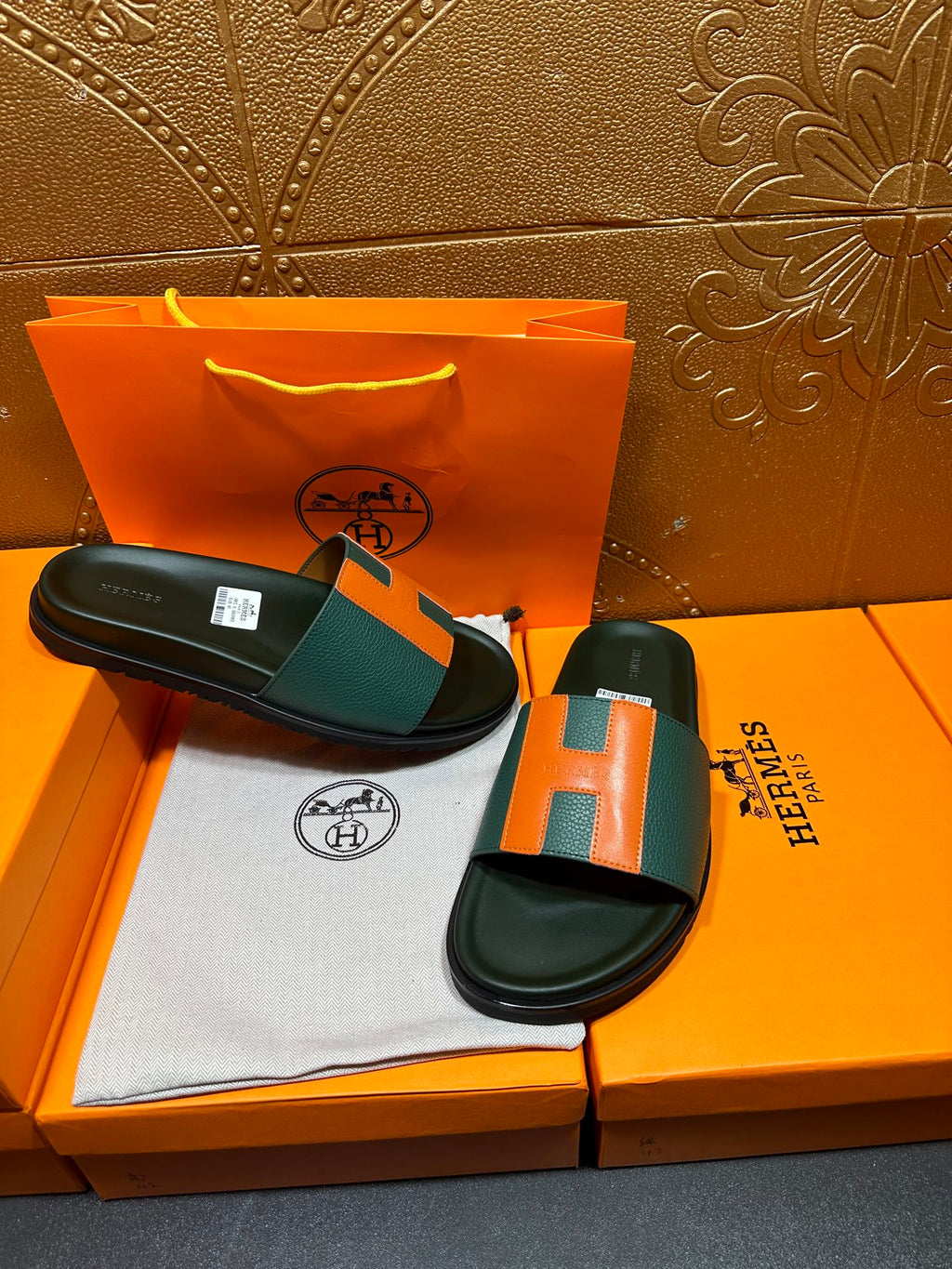 Hermes slide sandals with green and orange H straps, black sandals on shoebox