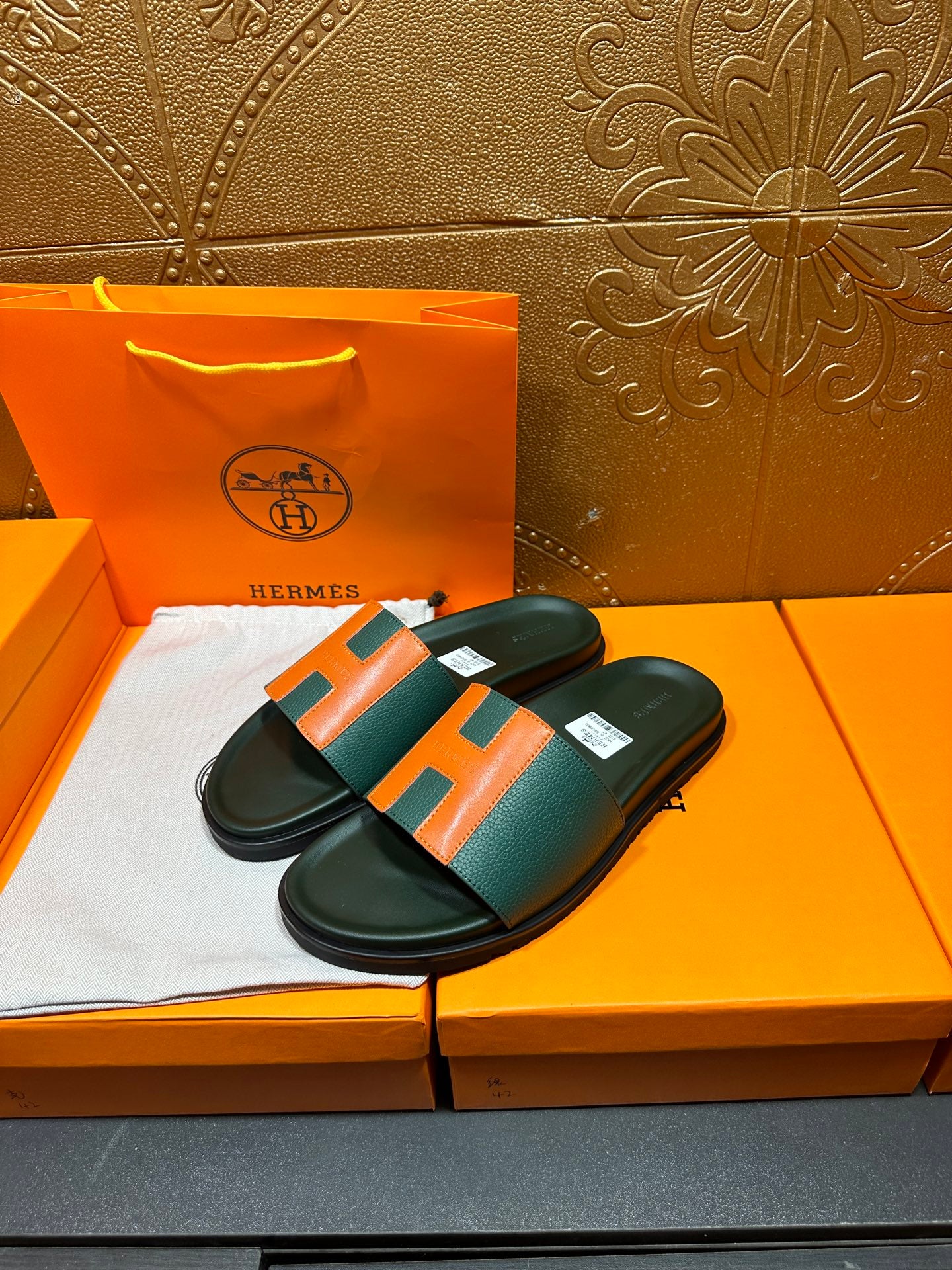 Hermes slide sandals with green leather straps and orange H buckle, black sole