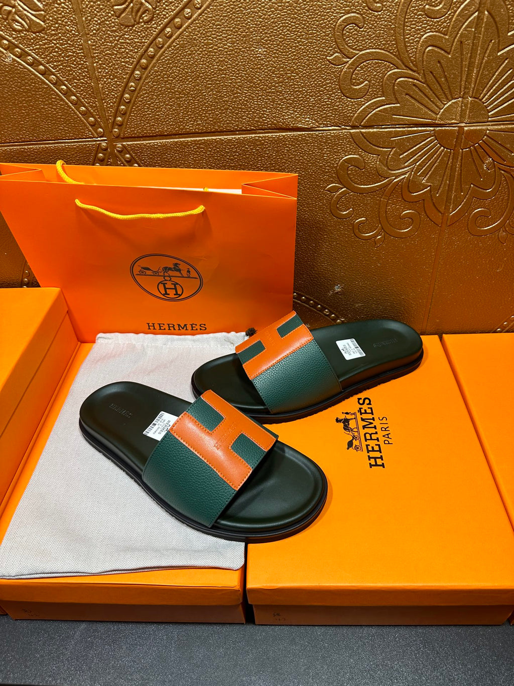 Hermes slide sandals on box, green upper with orange H accent and black footbed
