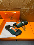 Hermes slide sandals on box, green upper with orange H accent and black footbed