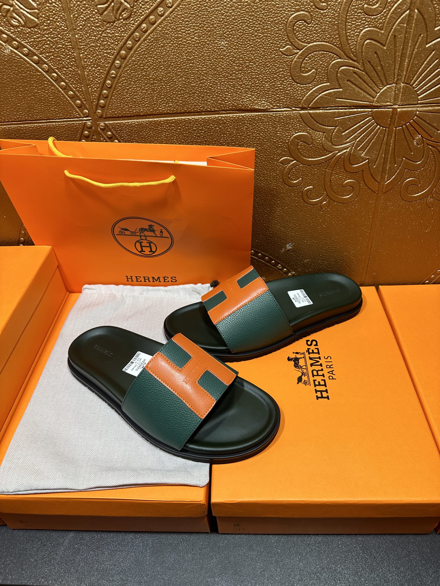 Hermes slide sandals on box, green upper with orange H accent and black footbed