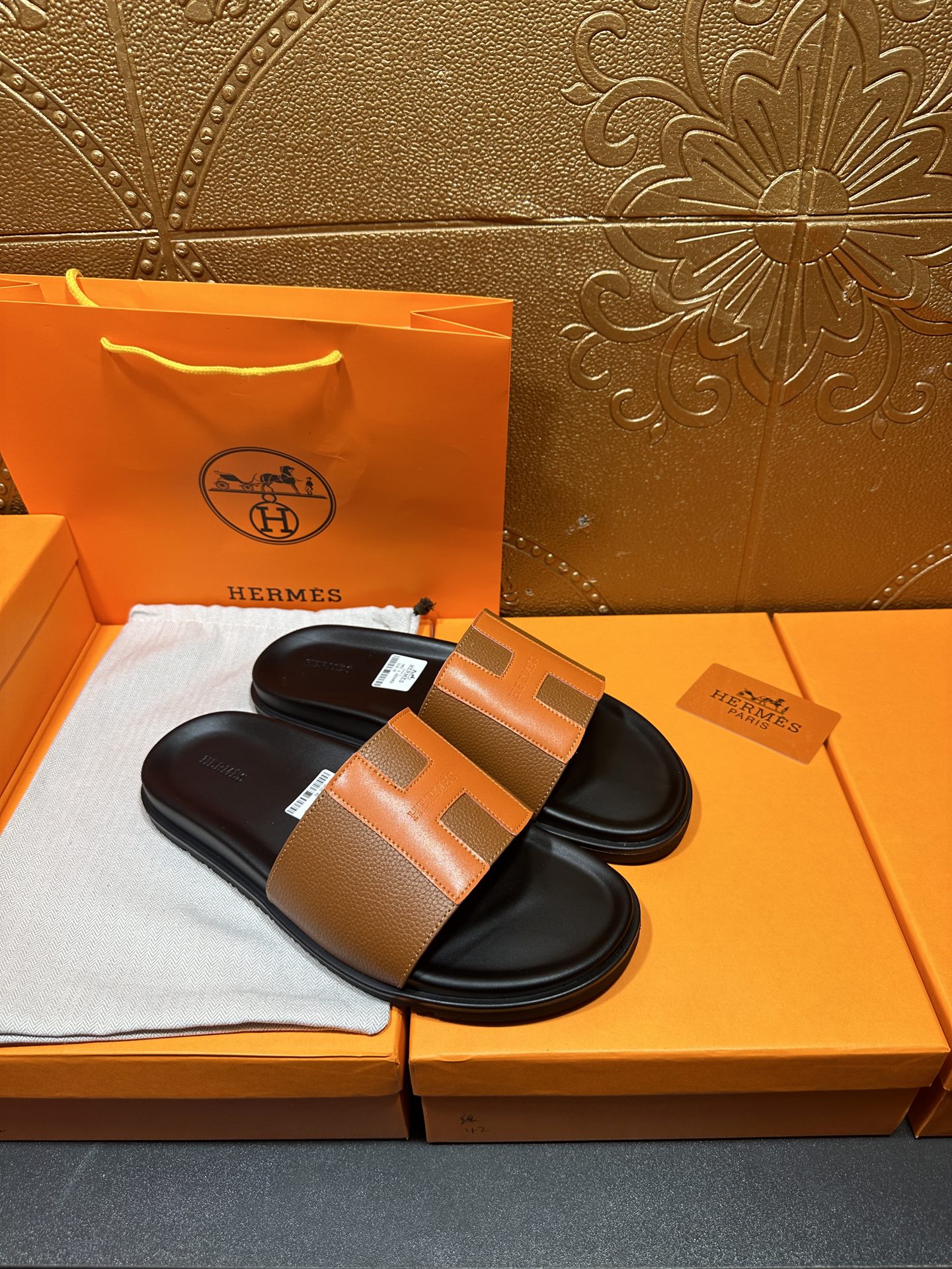 Pair of tan leather slide sandals with black footbeds and wide strap