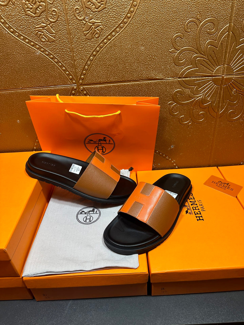 Tan leather slide sandals with black footbeds and wide strap, top view