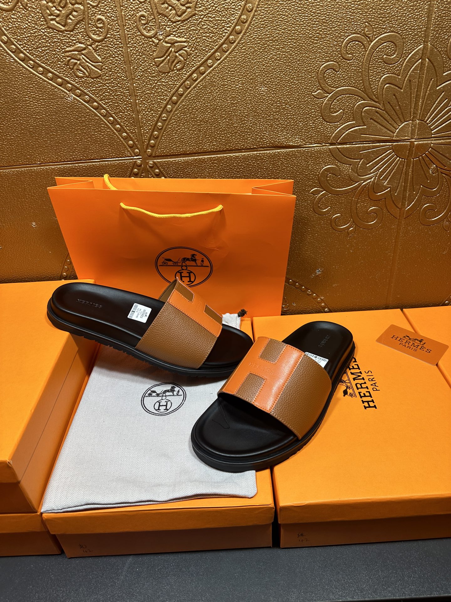 Tan leather slide sandals with black footbeds and wide strap, top view
