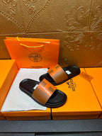 Tan leather slide sandals with black footbeds and wide strap, shown side-by-side