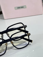 Close-up black eyeglass frame with clear lenses and MiuMiu logo on the temple