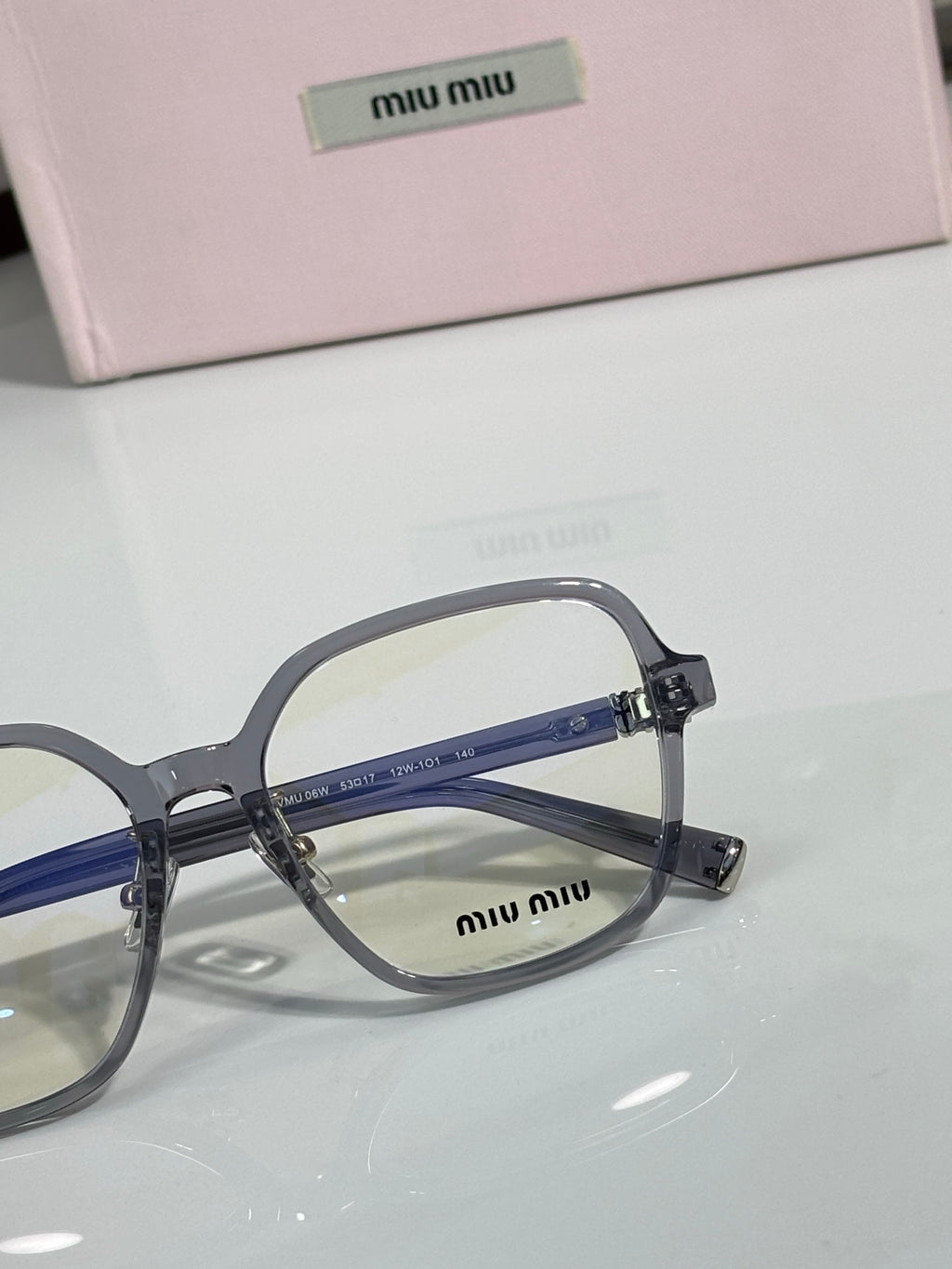 Gray full-rim eyeglasses with blue lens tint and MiuMiu logo on the front