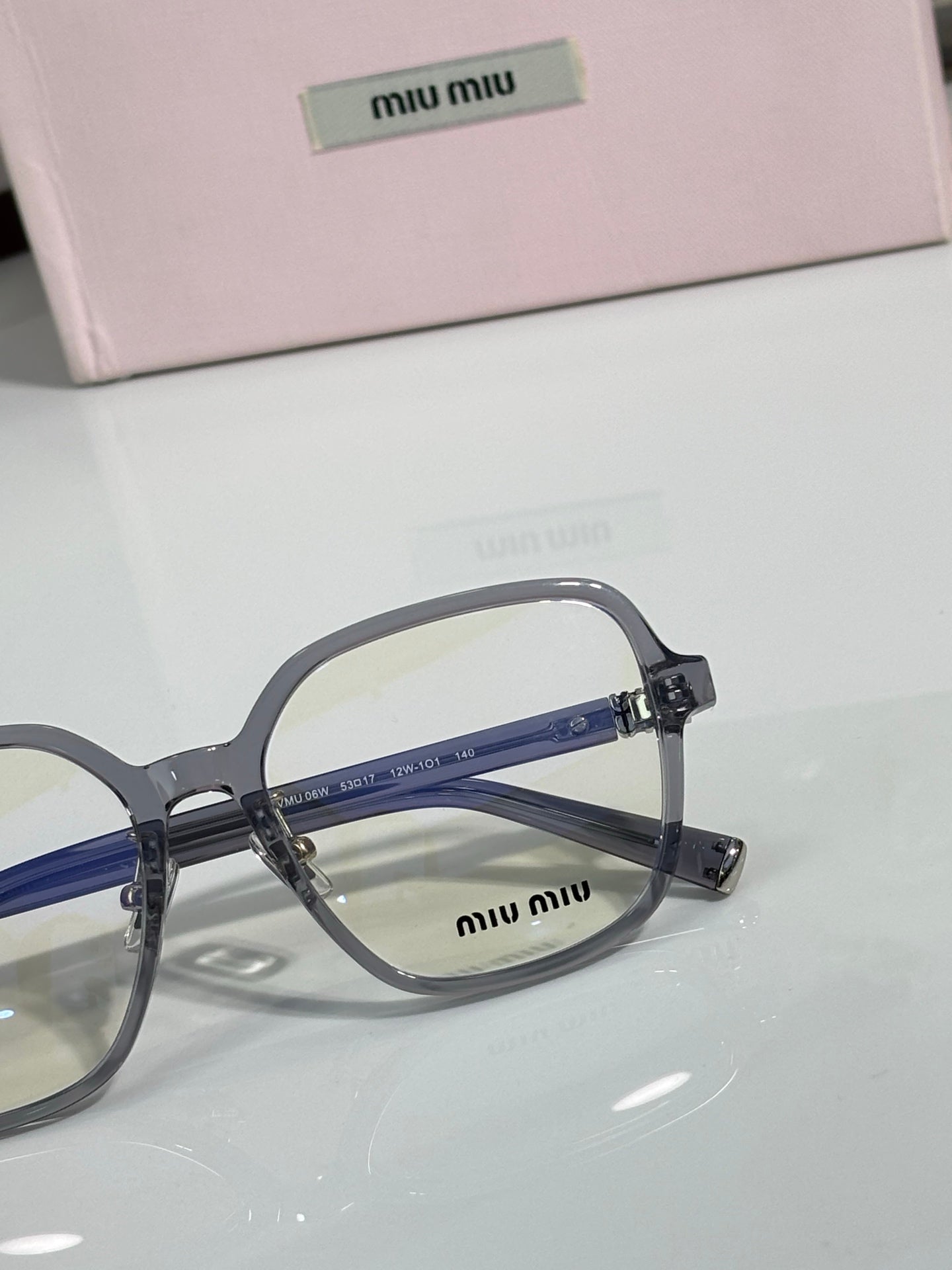 Gray full-rim eyeglasses with blue lens tint and MiuMiu logo on the front