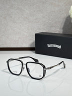 Black eyeglass frames with clear lenses and gold-tone accents along the arms.