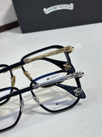 Dark navy eyeglass frames with clear lenses and gold-tone carved temple accents.