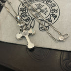 Silver-tone cross pendant necklace close-up with spring ring clasp on pouch