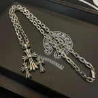 Silver cross pendant necklace with clasp and chain links on black tray