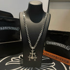 Silver chain necklace with cross pendant on black display bust