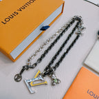 Louis Vuitton necklace set display, silver-tone and dark-tone chains with LV charm pendants