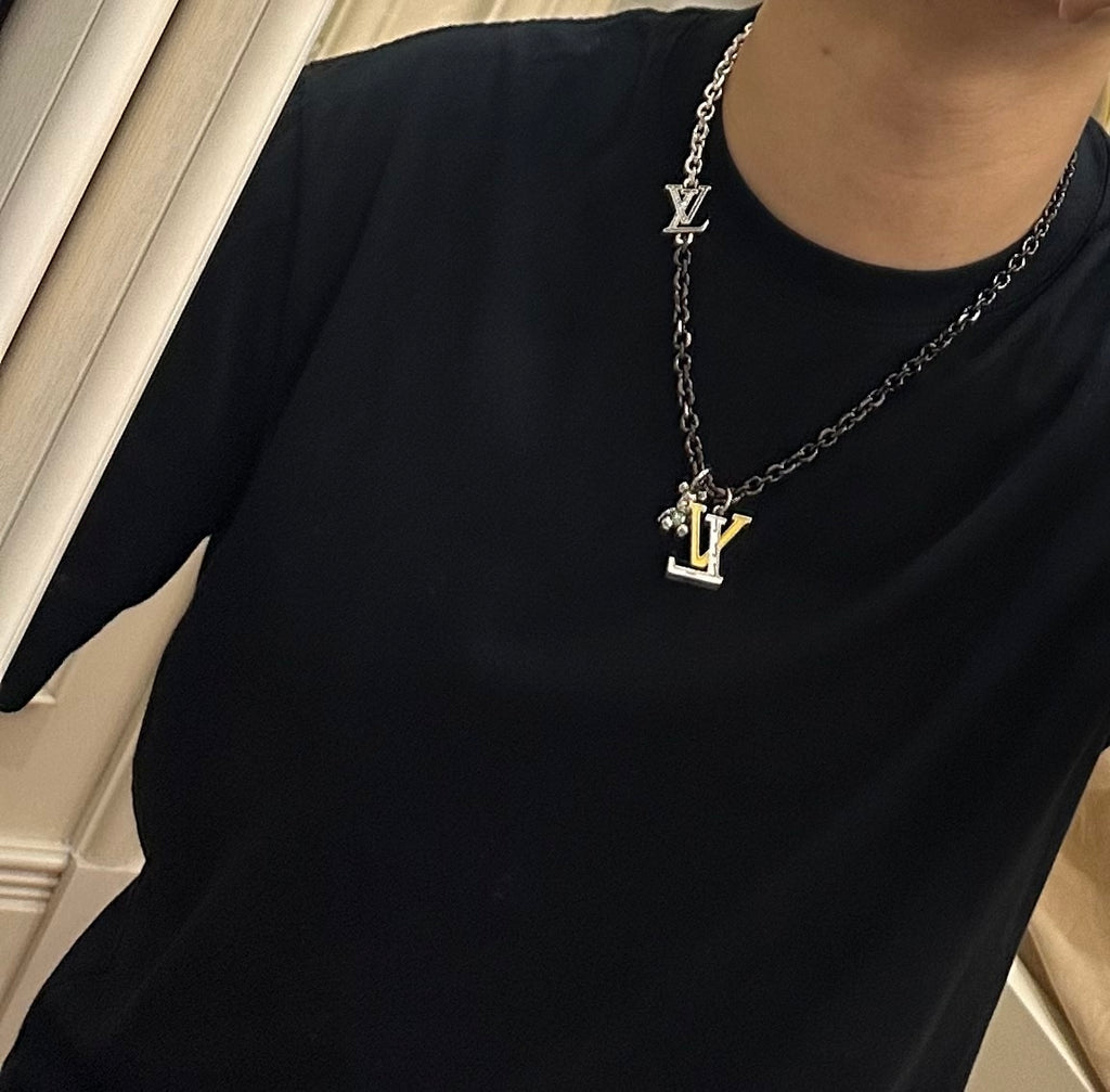 Louis Vuitton necklace on model, silver-tone chain with LV charm pendant